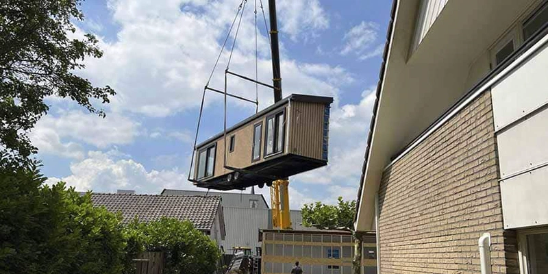 Mantelzorgwoning wordt met een kraan in de tuin gehesen